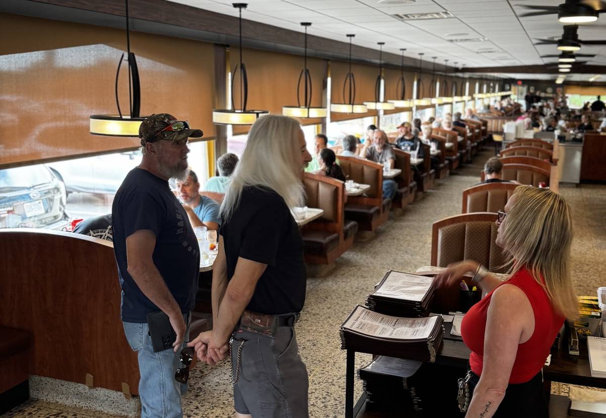 Inside Lancers Diner: a host greets two customers at the front stand while booths fill the long dining room behind them